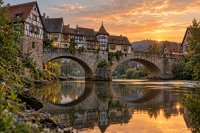 Steinbrücke mit Fachwerkhäusern am Abend